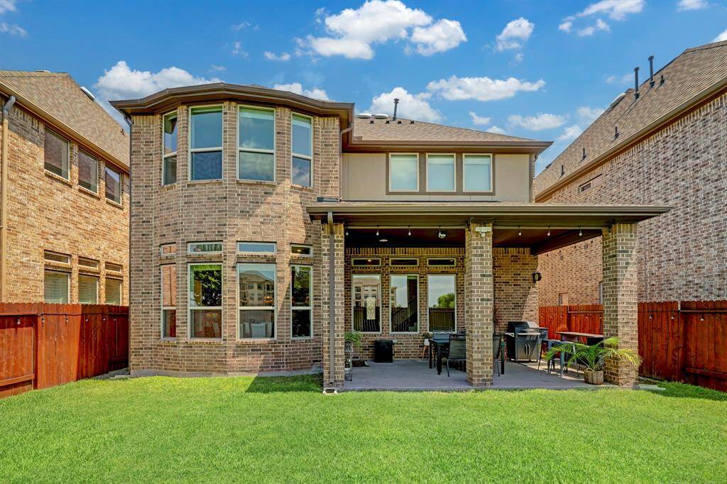 Behold the breathtaking view of the property's rear exterior, enhanced by the elegant presence of brick stone exteriors that beautifully accentuate its Traditional English design.