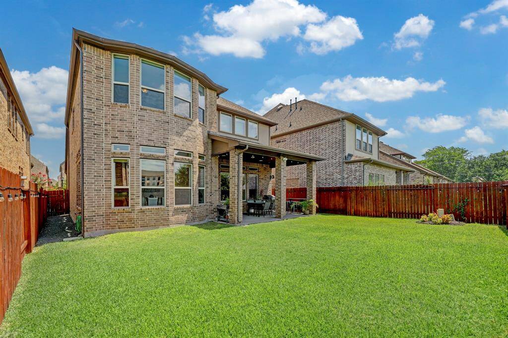 Take in the fabulous sight of the rear exterior, harmoniously blending with the lush green backyard.