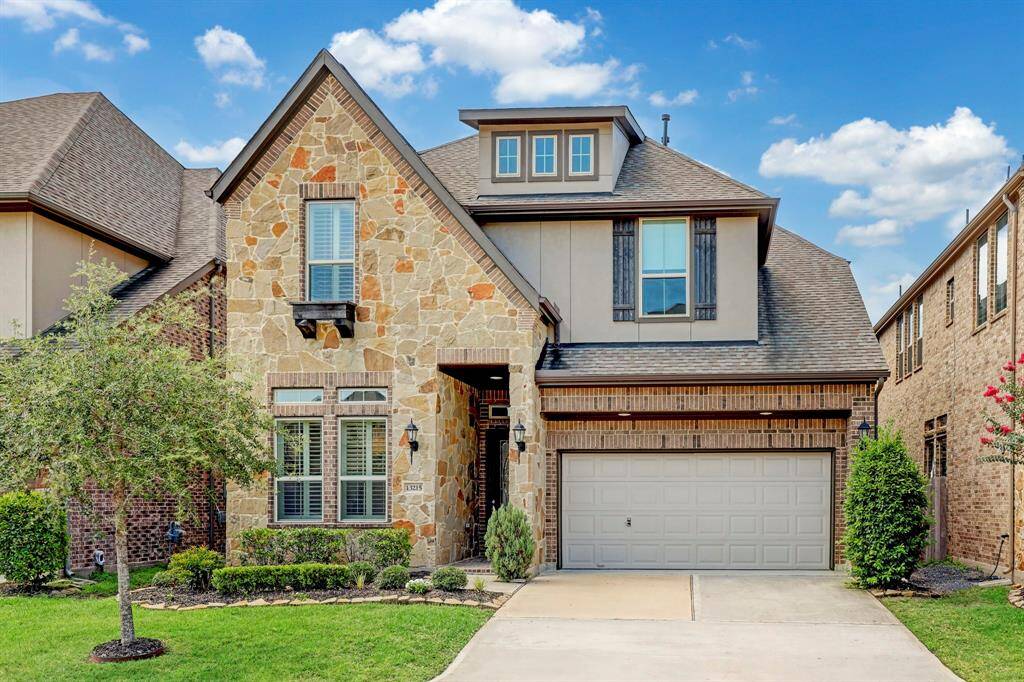 This property boasts a well-maintained front yard adorned with lush greenery, complemented by the convenience of a 2-car attached garage with ample space.