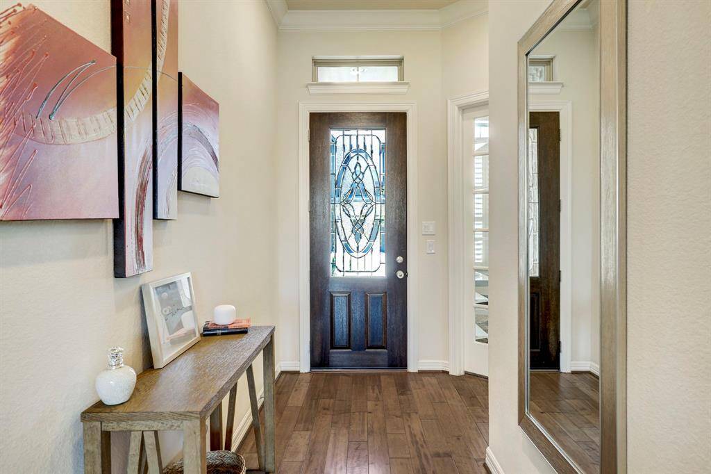 Step into this formal entrance, where you'll be captivated by an exquisite foyer featuring a soothing light-color palette and luxurious hardwood floors. This grand entrance also offers convenient access to the study area, adding functionality to its elegant charm.