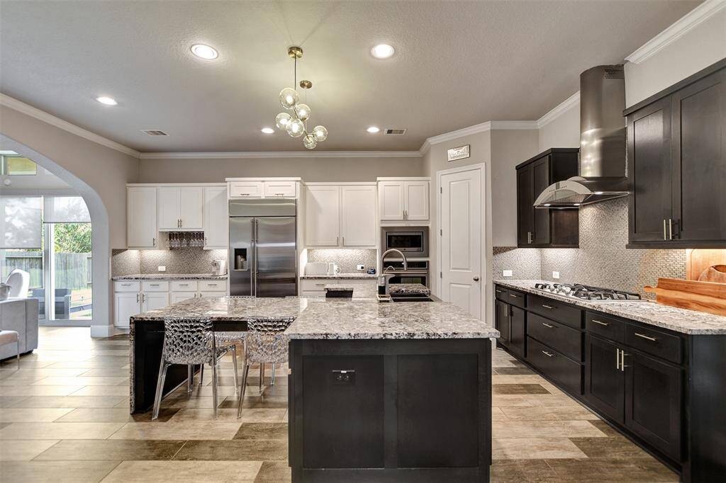 Modern and high-end countertops with a large T shape island with seating, and elegant lighting