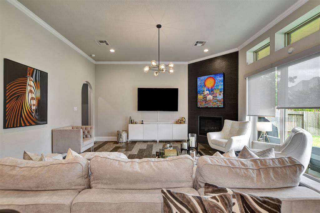 This living room features a modern design with a cozy fireplace set in an accent wall with sliding doors to the right for patio access and natural light.