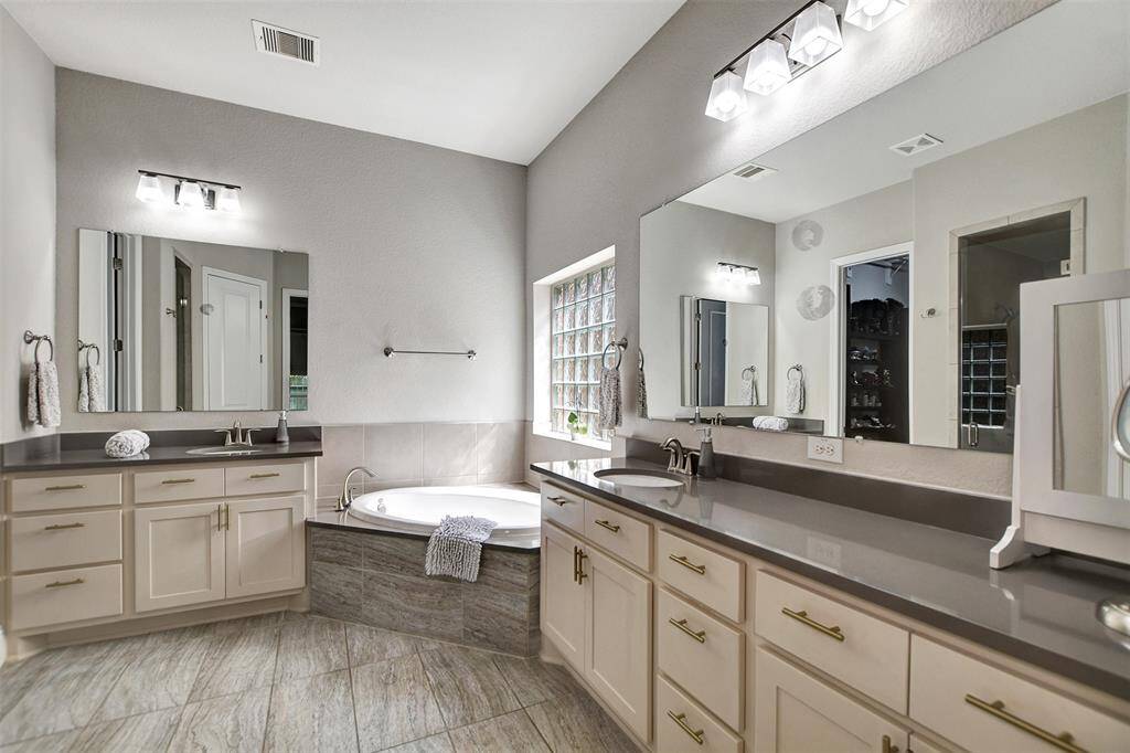 Primary bathroom, modern and spacious with lots of cabinet and counter space.