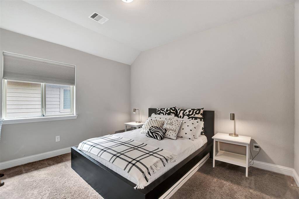 Spacious Fourth bedroom with abundant natural light from large windows. The neutral walls and carpet create a warm and relaxing atmosphere.