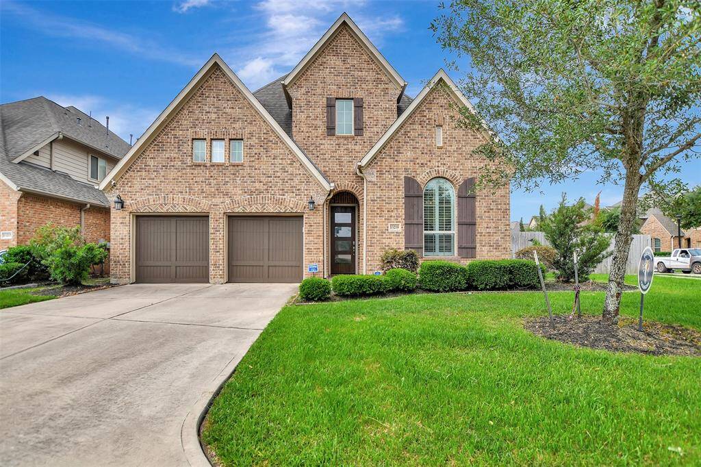 Modern two-story house with a clean, exterior design. It features large windows, a well-maintained front lawn, and a long driveway. This homes welcomes you with an elegant door.