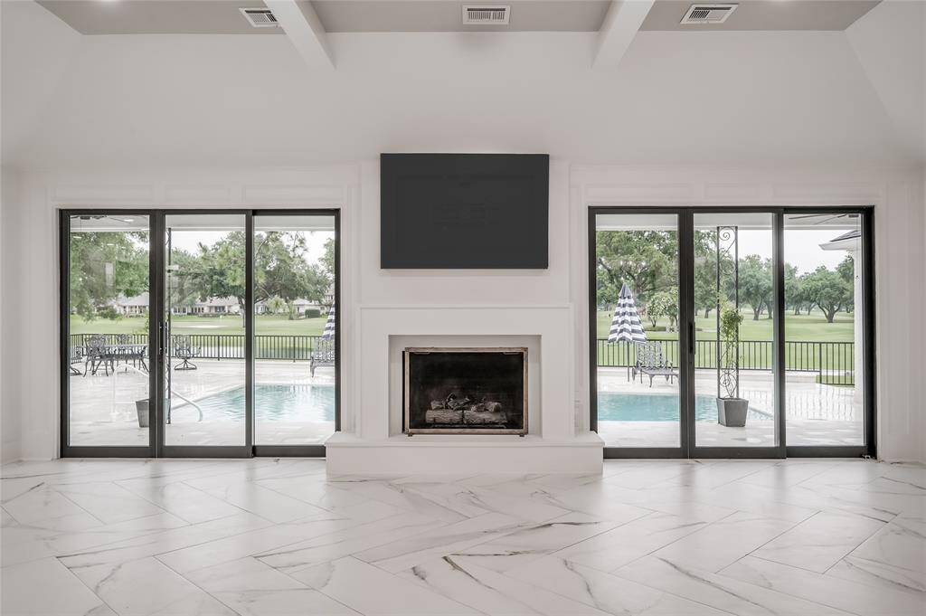 Central fireplace flanked by glass doors creates a dramatic focal point in the great room.