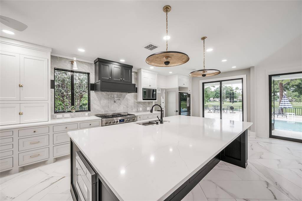 White quartz countertops and floor to ceiling soft-closing custom cabinetry with under cabinet lighting.