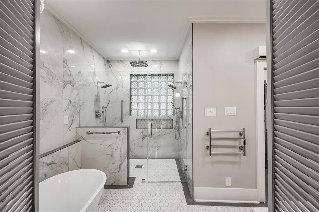 Owner's suite spa-like bathroom features a walk-in shower and freestanding garden tub.
