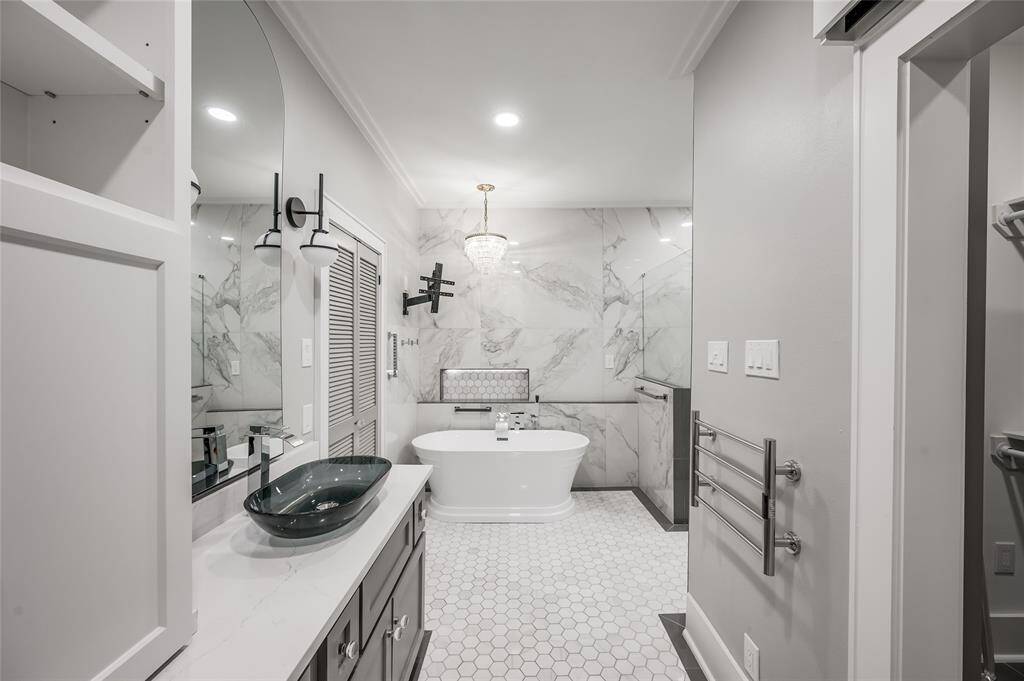 Vintage crystal chandelier provides soft lighting over the garden tub.