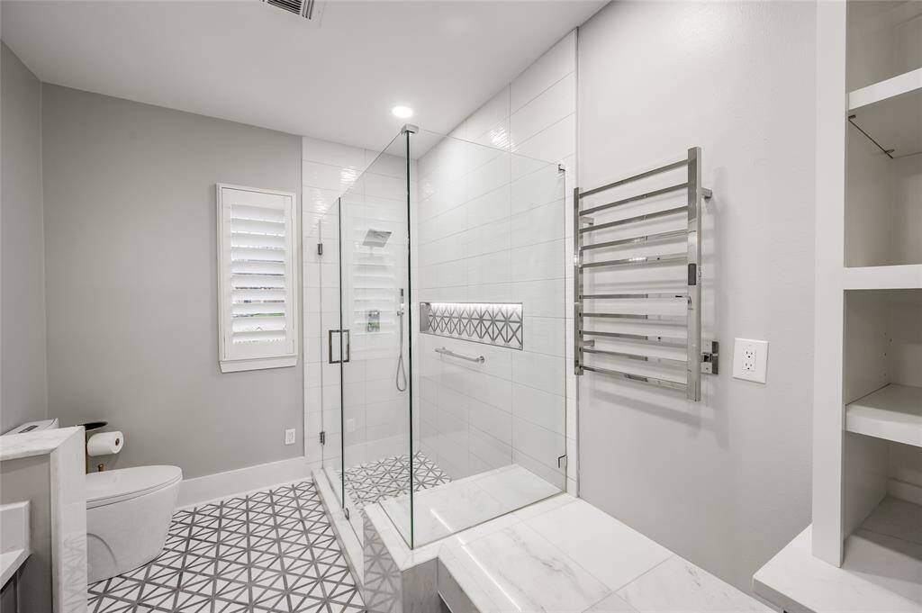 Rain shower head and hand-held shower. The shower also includes a built-in seat, large shampoo/soap niche and towel bar.