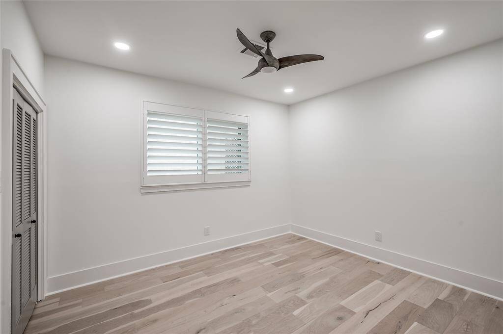 One of two secondary bedrooms both featuring modern lighted ceiling fans and recessed lighting.