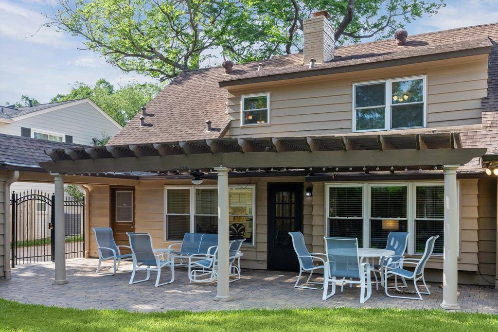 Beyond the patio, the backyard unfolds into a tranquil retreat, richly landscaped with mature trees and vibrant greenery that provide natural shade and privacy.