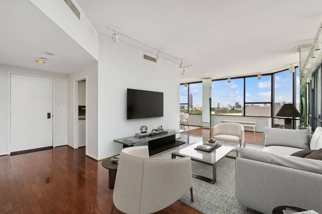 Large living room with 10 ft. ceilings and Northwest views overlooking the Galleria skyline. Image shown virtually staged.