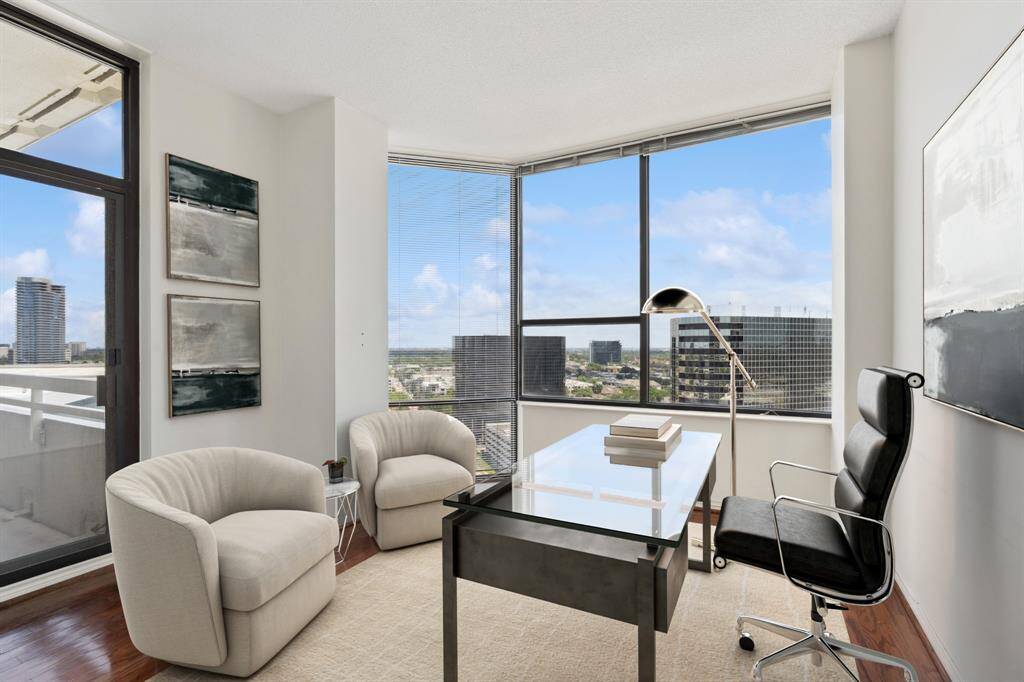 Bedroom currently used as a study or den with access to the balcony. Image shown virtually staged.