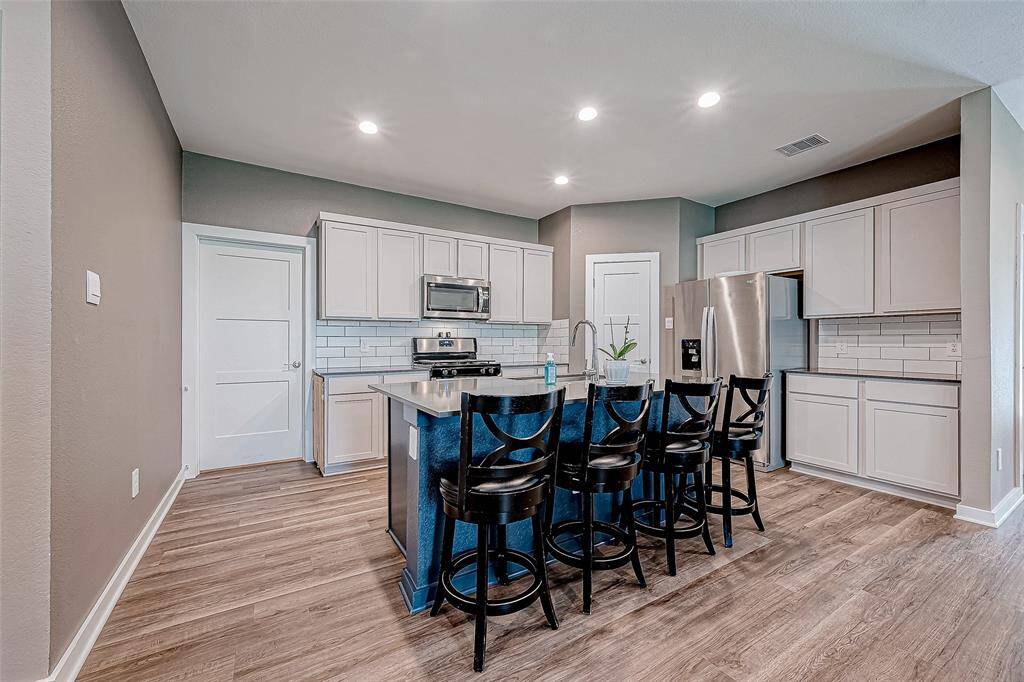 Cozy kitchen featuring a stylish coffee bar and inviting breakfast bar.