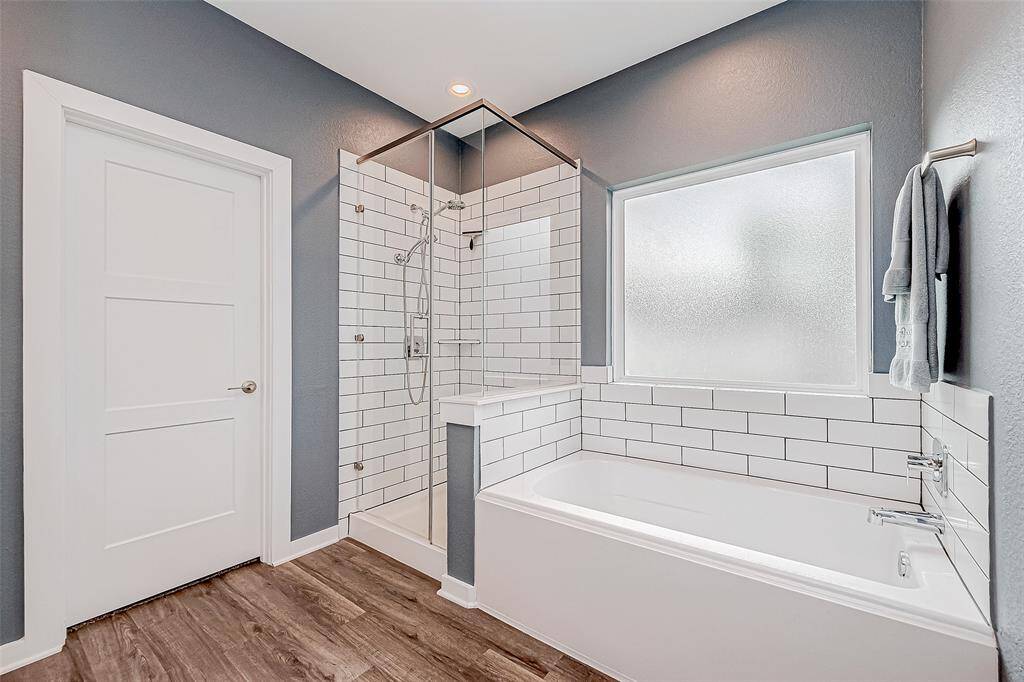 The luxurious primary bathroom features a soaking tub, a separate shower, dual vanities, and two spacious walk-in closets.