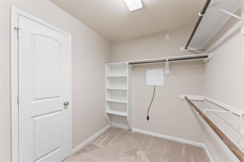 The primary bedroom features a spacious walk-in closet designed for both style and function. With plenty of room to organize clothing, shoes, and accessories, it offers excellent storage without feeling cramped.