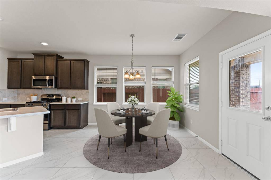 Enjoy morning coffee or casual meals in the cozy breakfast area. Wide windows fill the space with light and provide lovely views of the backyard.