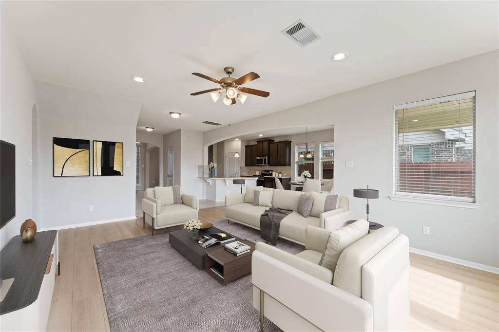 Natural light pours in through large windows, creating a cheerful space to relax or entertain.