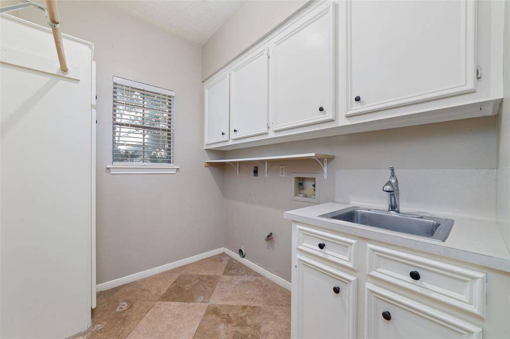 Utility room provides ample cabinet space with sink and broom closet- first floor