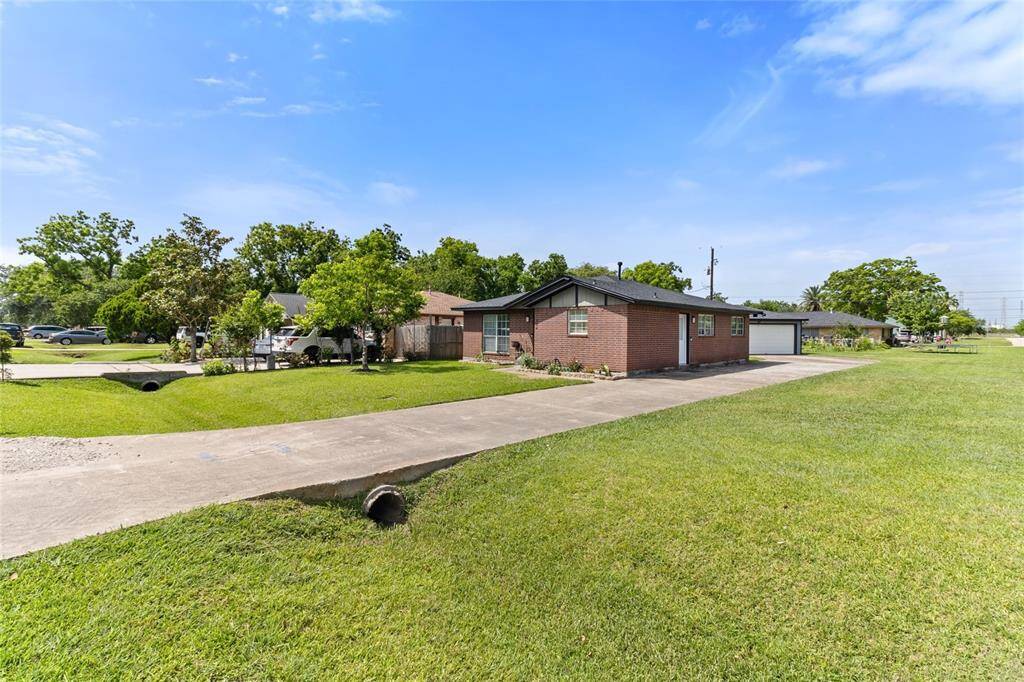 Extended driveway offers ample parking for multiple vehicles—perfect for guests, boat storage, or extra work vehicles—with easy access to the detached garage in the back.
