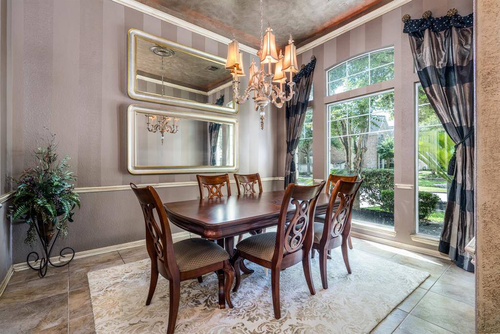 The elegant formal dining room with custom draperies and luxurious finishes.