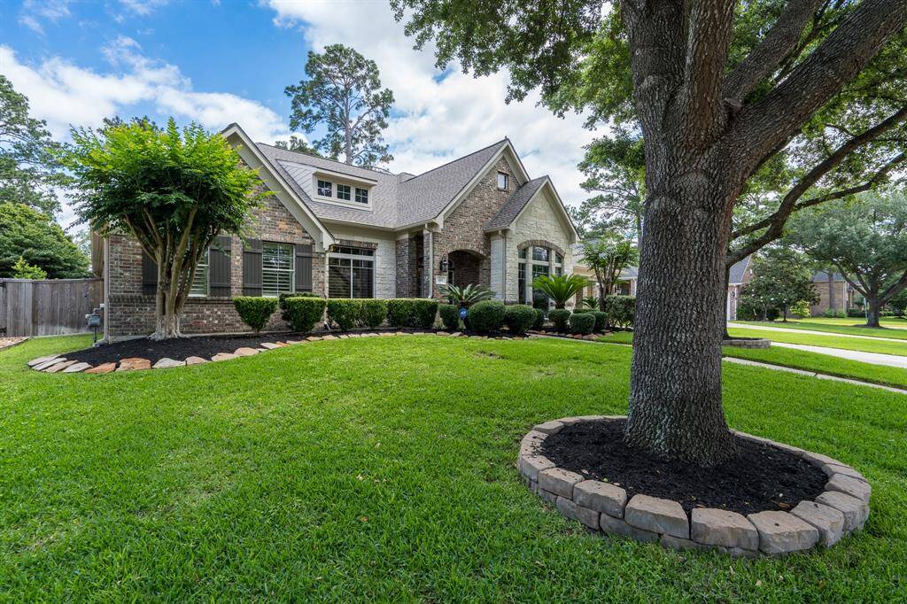 Another view of the exterior of the home with the mature oak trees and beautiful landscaping.