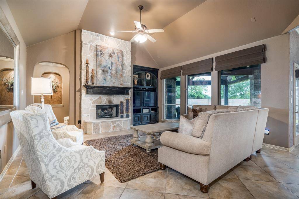 The living room overlooks the patio and large backyard and showcases a gorgeous stone fireplace.
