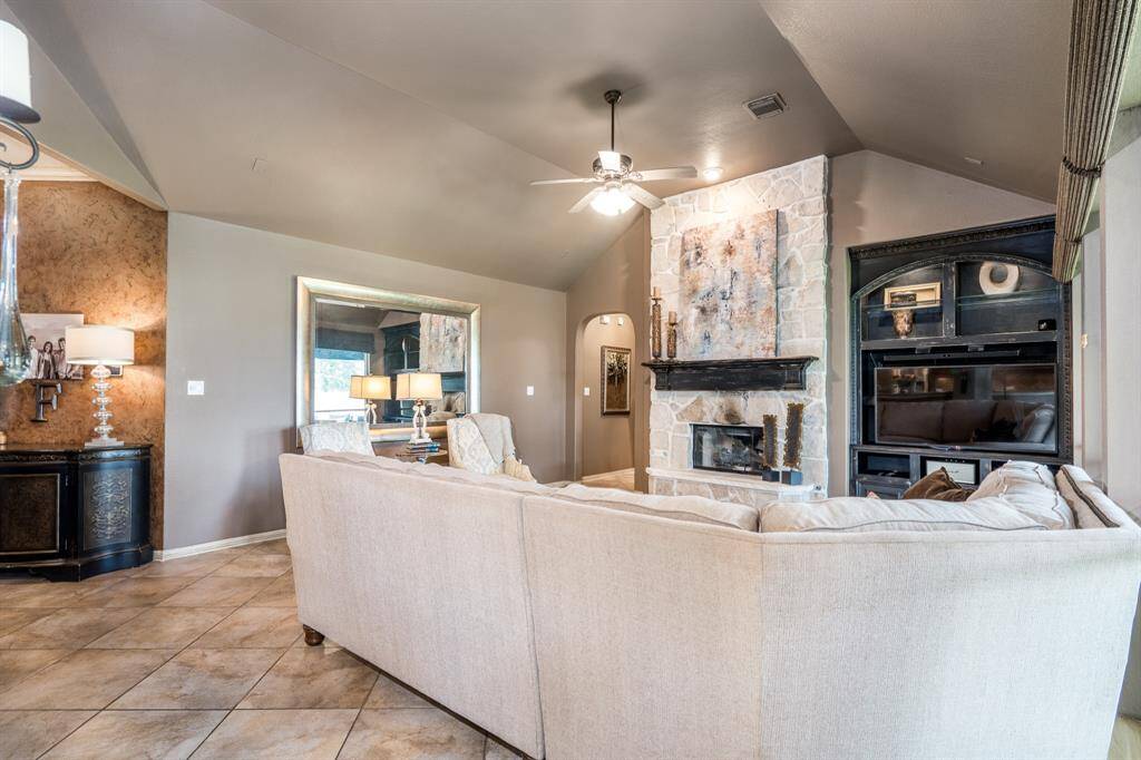 Living room boasts a vaulted ceiling, rock fireplace and huge windows.