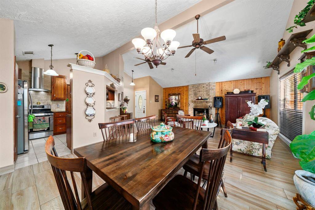 Dining room is adjacent to the updated remodeled kitchen with custom cabinets, stainless steel appliances, a stylish vent hood, elegant countertops, a chic backsplash, and more.