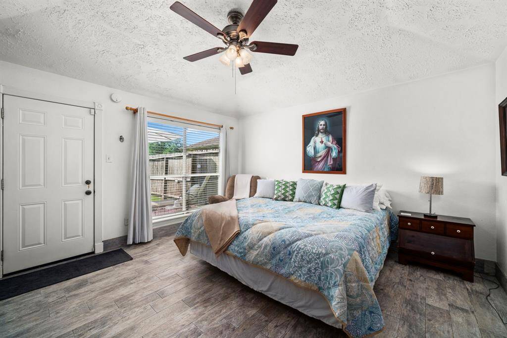 Expansive primary bedroom featuring high ceilings and low-maintenance tile flooring. A large picture window offers stunning views of the backyard, and this room includes direct access to the outdoor space.
