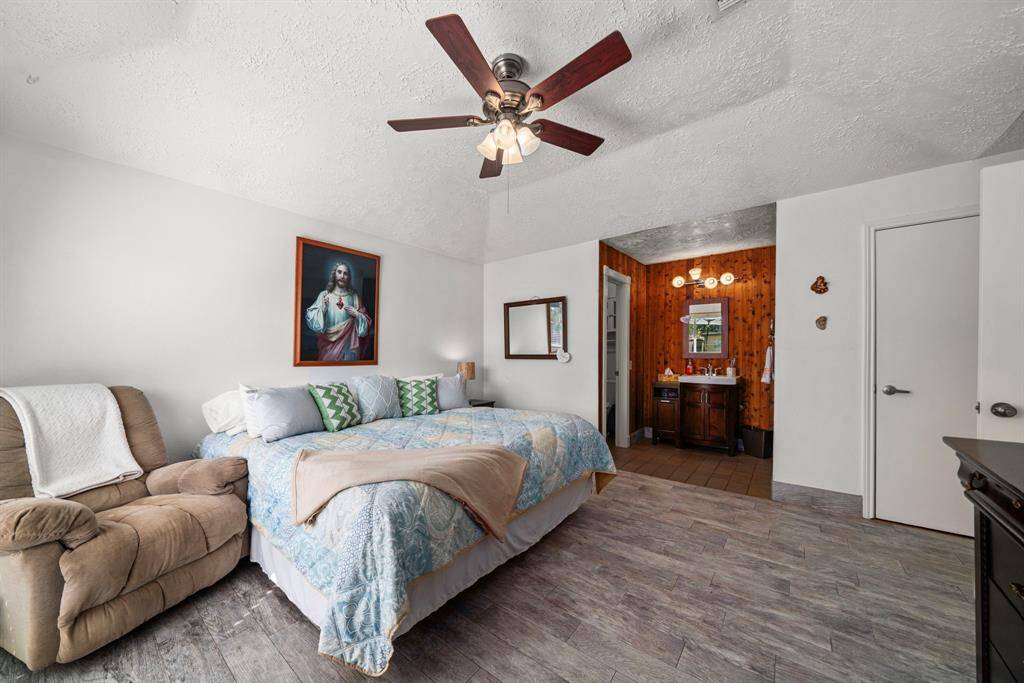 Expansive primary bedroom featuring high ceilings and low-maintenance tile flooring. Spacious walk-in closet and updated primary bathroom with walk-in large shower