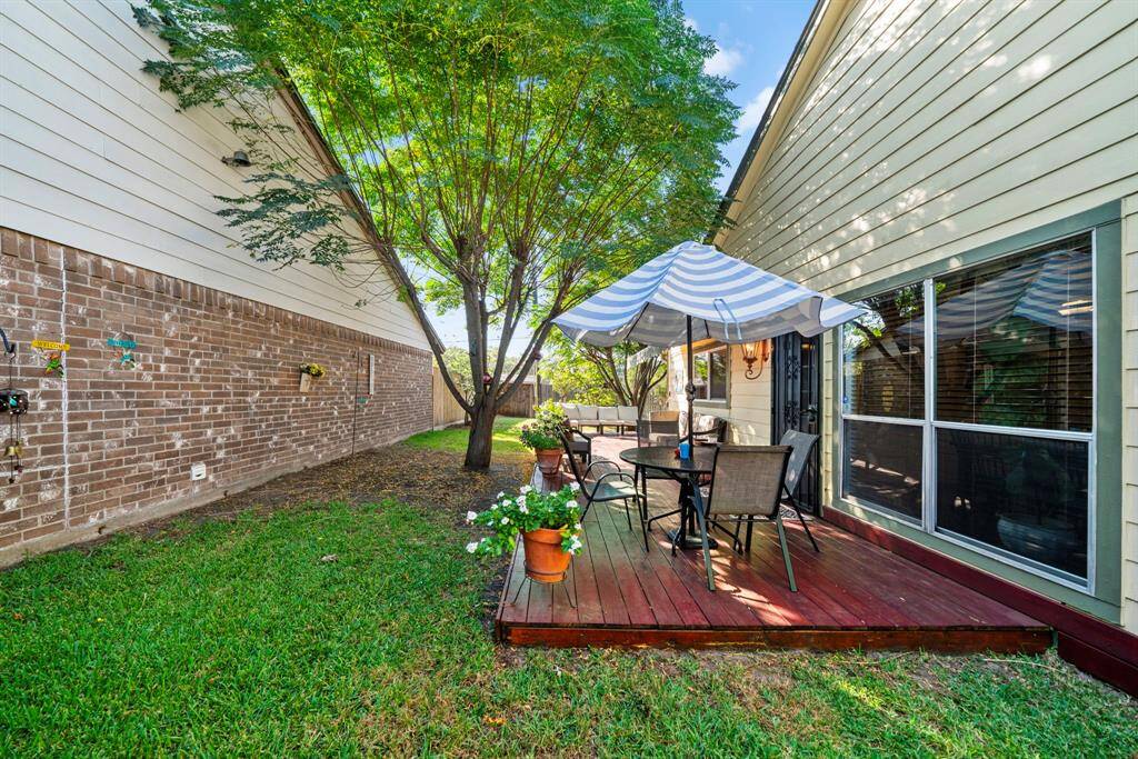 Spacious backyard with a wrap-around wooden deck, ideal for multiple seating areas.