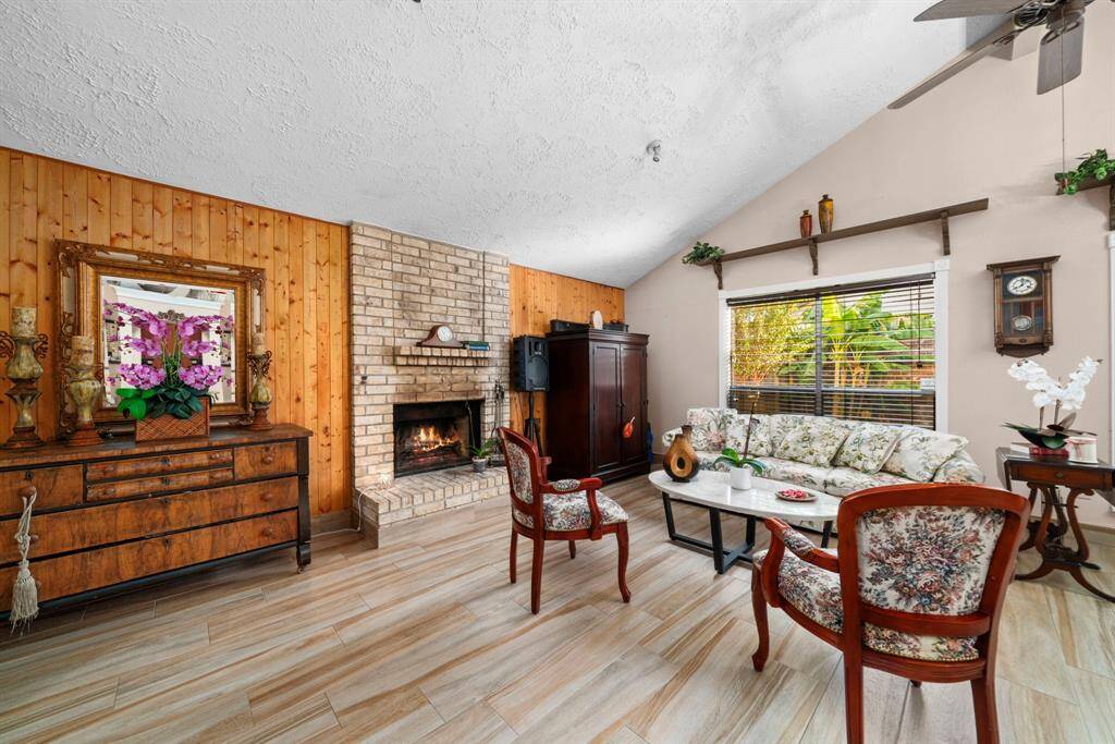 The home welcomes you into a cozy and bright living room, complete with a large fireplace. Home is appointed with high ceilings and large windows offering plenty of natural light