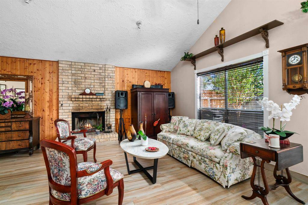 Cozy and bright living room, complete with a large fireplace and large windows offering views of the large wood deck and beautiful backyard.