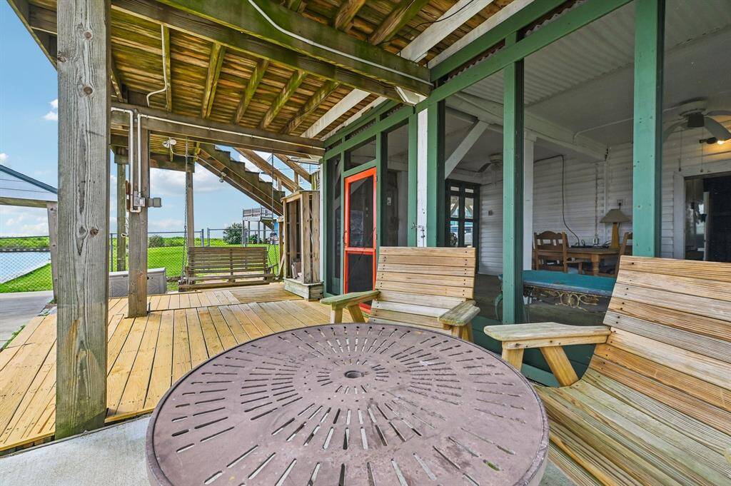 This photo showcases a spacious deck with artificial turf, featuring a scenic waterfront view. It includes outdoor seating, ideal for relaxation or entertaining, and is adjacent to a home with large windows for ample natural light.