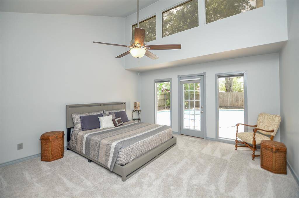 Primary Bedroom with a view of both the pool and stars.  Neutral paint and carpet make an easy backdrop.