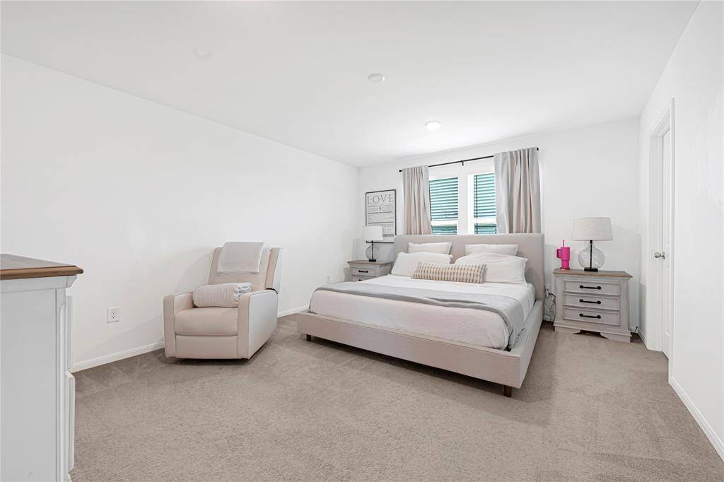 Spacious primary suite offers comfort and privacy with soft natural lighting.