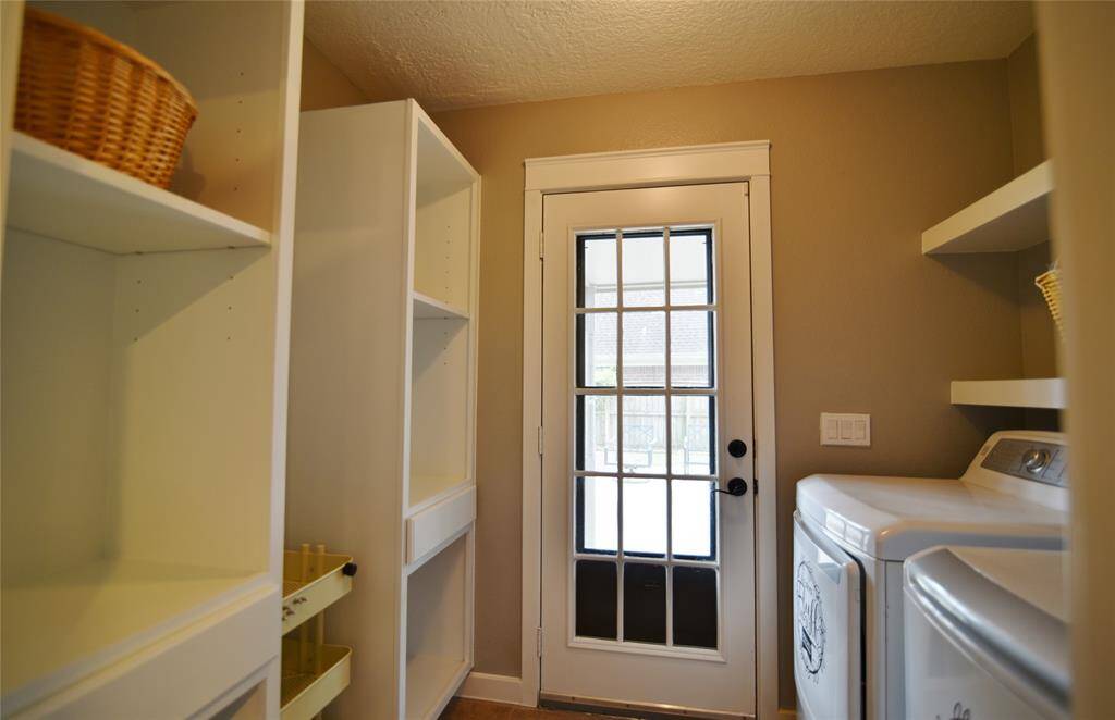 Opposite side view of the utility room with custom cabinetry built-in for your convenience and extra storage space...French door with storm door leads to the covered walkway to the garage....