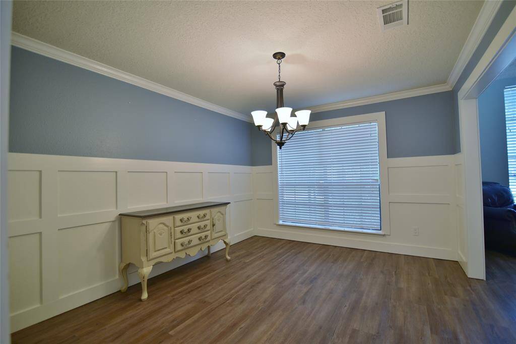 Formal dining room has wainscot paneling and crown molding to add stately elegance with ample room for a large dining table and china cabinet....