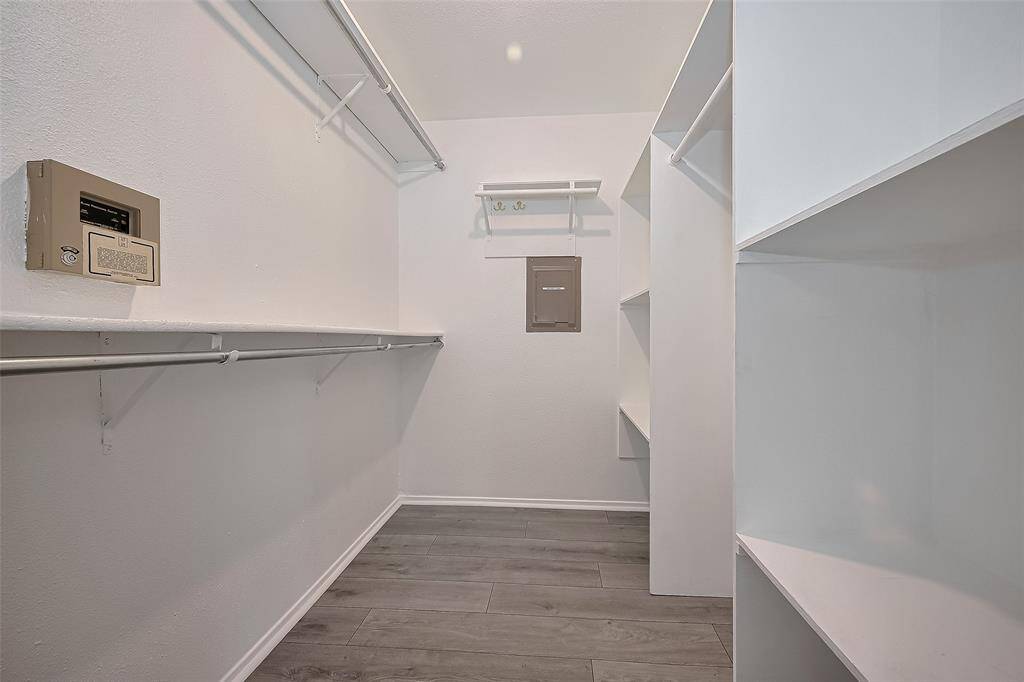 Primary closet is a  haven with shelving and strategically placed hanging poles! Perfect for showcasing your clothes, storing luggage, and arranging your shoes and bags, it’s time to elevate your space to make finding your favorite items effortless and stylish.