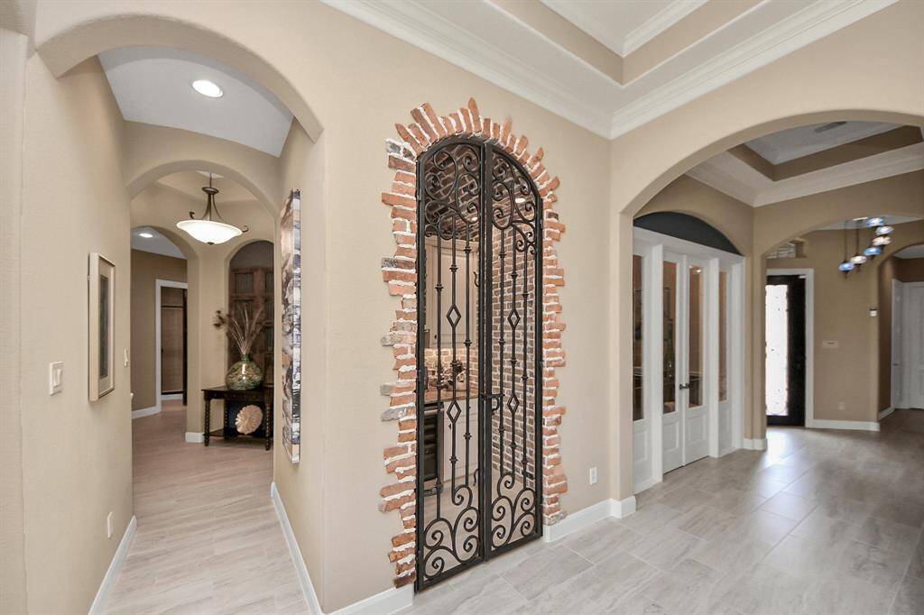 As you enter through the front door you are meet with high tray ceilings with crown molding and archways with beautiful custom lighting throughout the home.