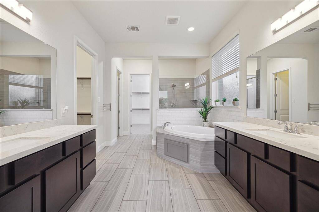 The primary bathroom showcases dual vanities, a large soaking tub and an oversized shower.