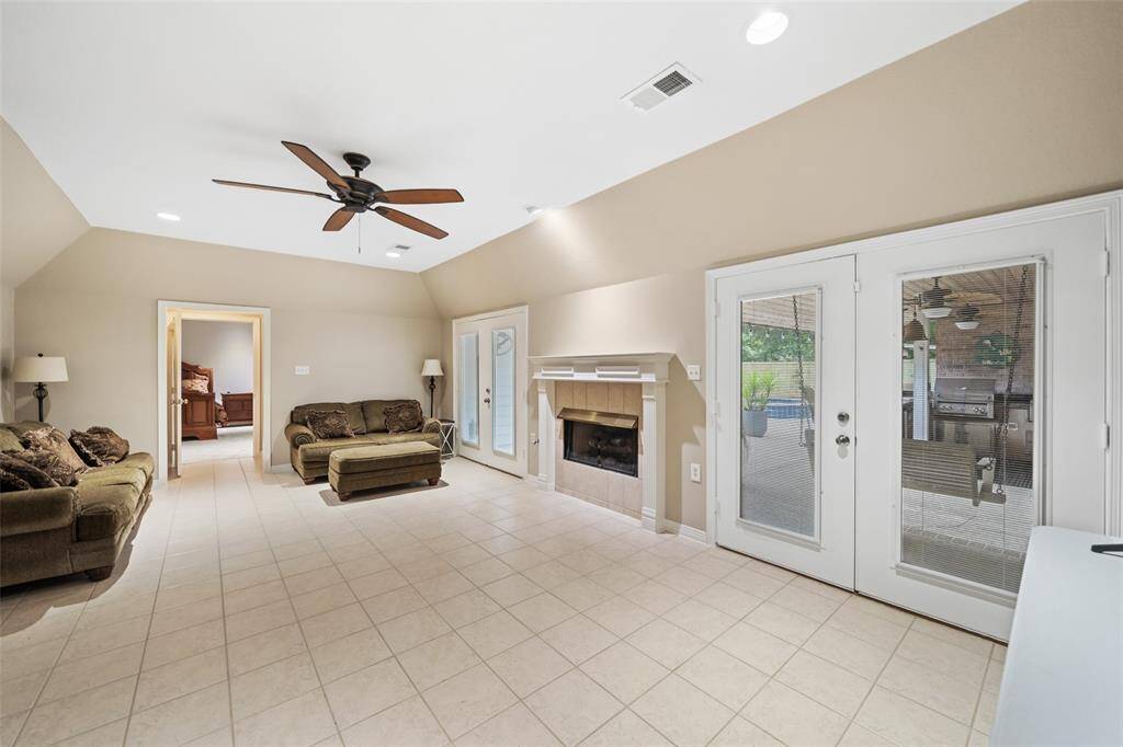 Two sets of French doors fill the family room with natural light and offer seamless access to the covered patio and sparkling pool, perfect for indoor-outdoor living and effortless entertaining.