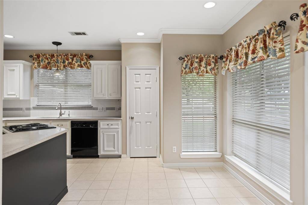 Enjoy Wednesday night lasagna or Saturday morning pancakes in this charming breakfast area with picture-perfect views of the covered patio, summer kitchen and pool.