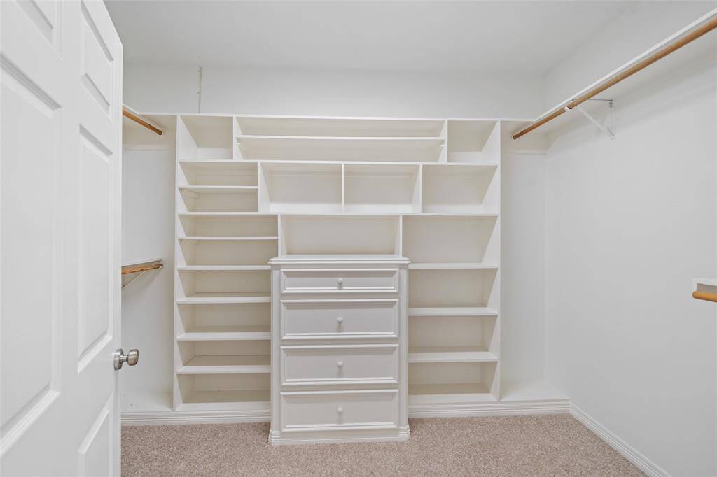 Shop until you drop, this massive walk-in closet has you covered with custom built-ins, ample hanging space, and all the room you need to stay stylishly organized.