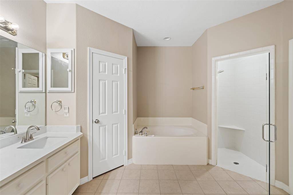 Relax and soak your worries away in this luxurious jetted tub or enjoy a quick rinse in the spacious walk-in shower with a bench and a frameless glass door. Either way, you'll love this private retreat.
