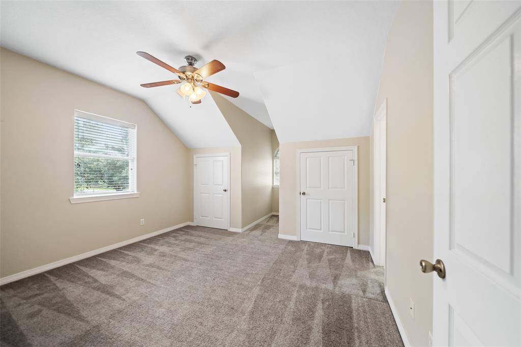 This spacious upstairs suite is full of charm, featuring plush carpeting, a cooling ceiling fan, neutral finishes, ensuite access to a shared bathroom and dual closets that offer ample storage creating a comfortable retreat for family or guests.