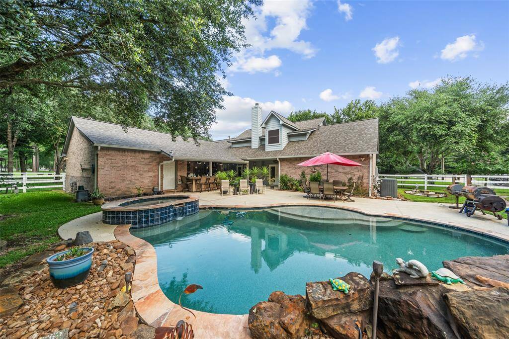 Welcome to your private paradise. Set on 3 acres, this backyard is designed for unforgettable days and peaceful nights, featuring a sparkling pool with rock waterfall accents, a raised spa, and expansive patio space perfect for lounging or dining al fresco. Surrounded by lush greenery and complete with a covered patio and summer kitchen, it’s outdoor living at its finest.