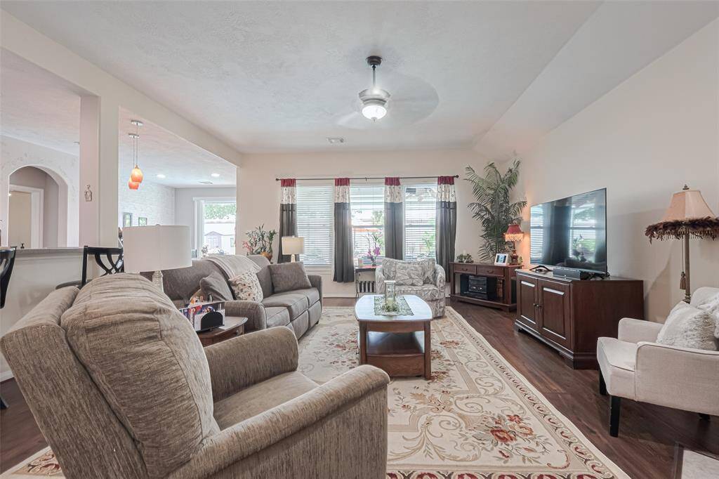 Rich laminate wood floors and abundant natural light create a warm, inviting atmosphere